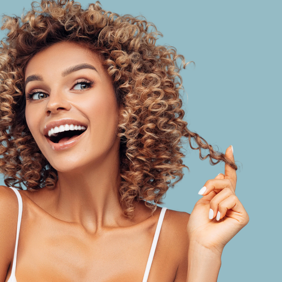 Finger coiling technique used to define individual curls for a polished curly hairstyling.