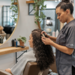 Salon Hair Treatments for Curly Hair - a stylist applying a specialized hair treatment to a client's curly hair in a modern salon setting.